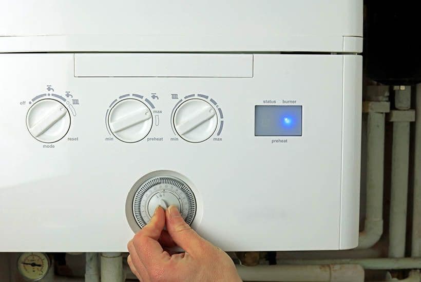 Picture of someone changing the temperature on a boiler