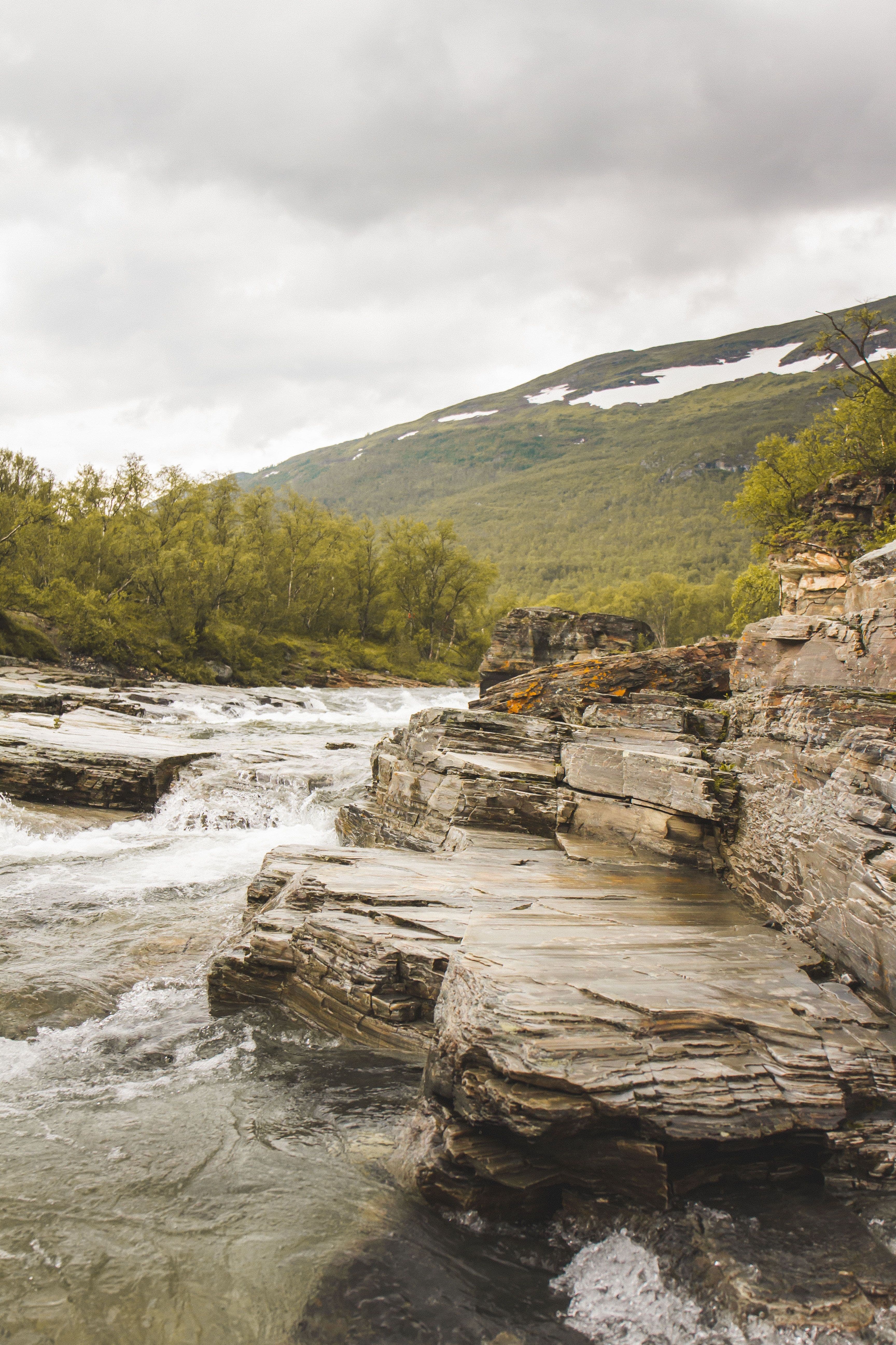 Water flowing down a mountain river with rock formations.